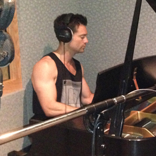 Joe McGowan, playing piano at his home studio.